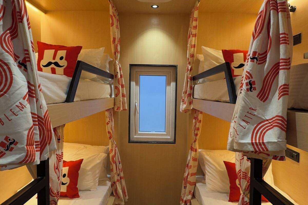 A bunk room with two beds, a window, and a ceiling fan.