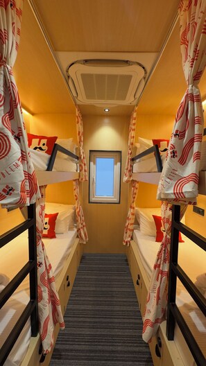 A narrow corridor with bunk beds, a window, and a ceiling vent. - Moustache Jaipur (Jaipur)