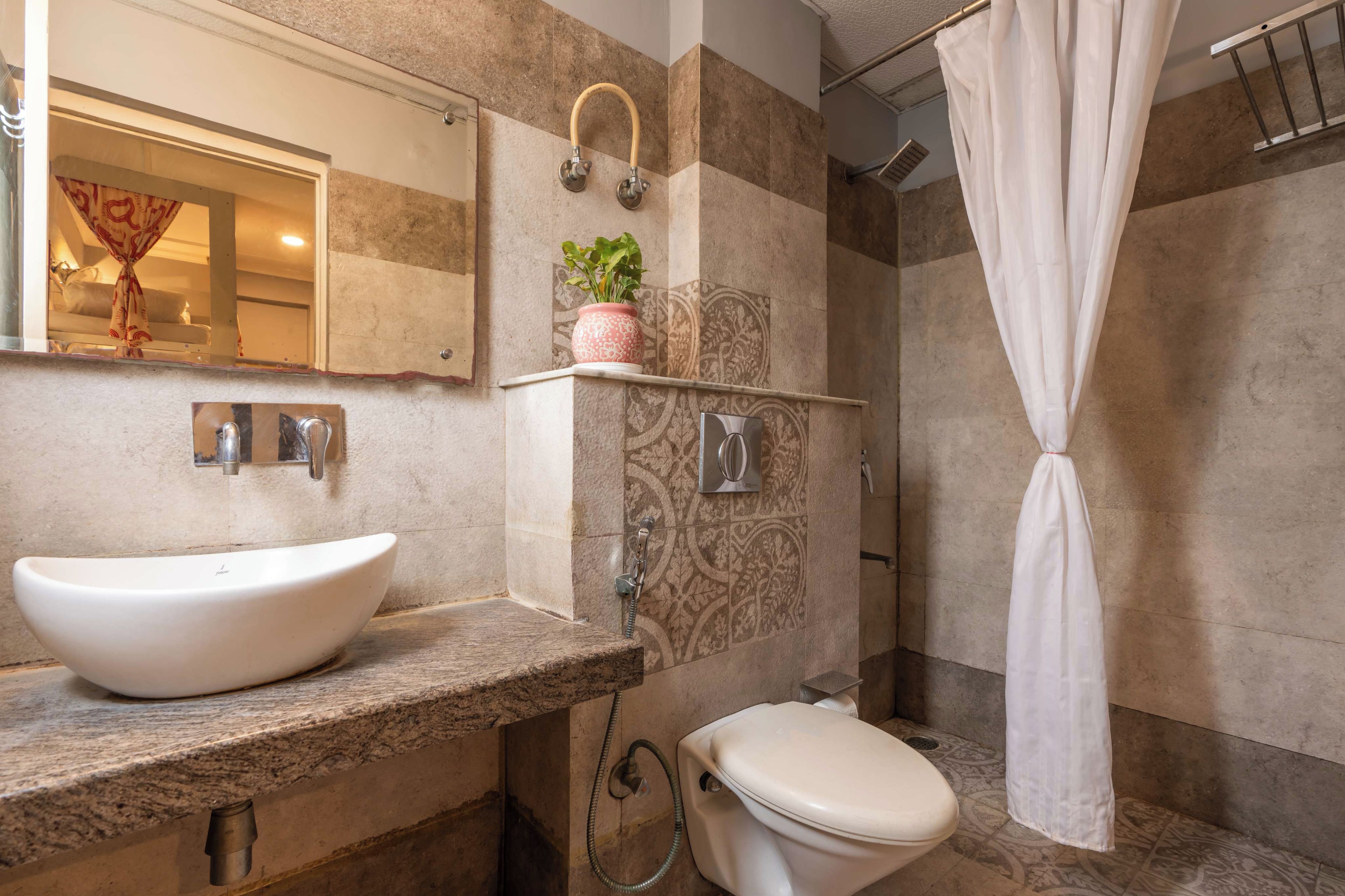 Een badkamer met een wit wastafelmeubel, toilet en douche.