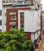 Un edificio a più piani con un bar al piano terra, una segnaletica da ostello e una scala che conduce a un livello superiore.