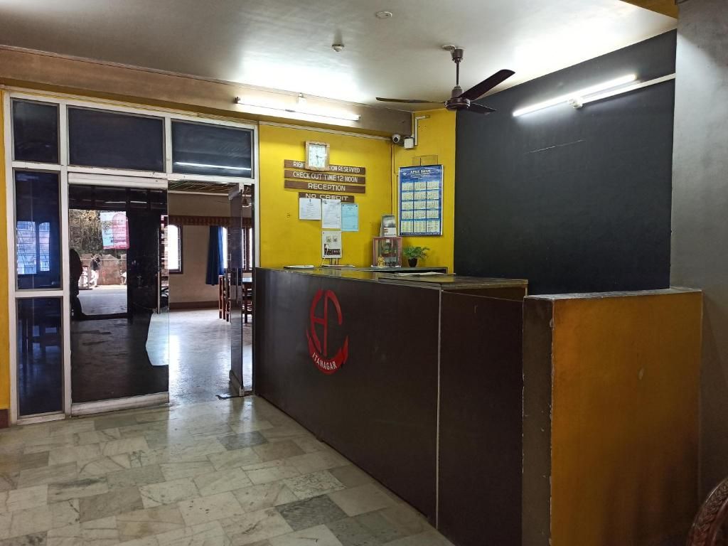 A reception area with a check-in counter, a reception desk, and a wall with posted notices.