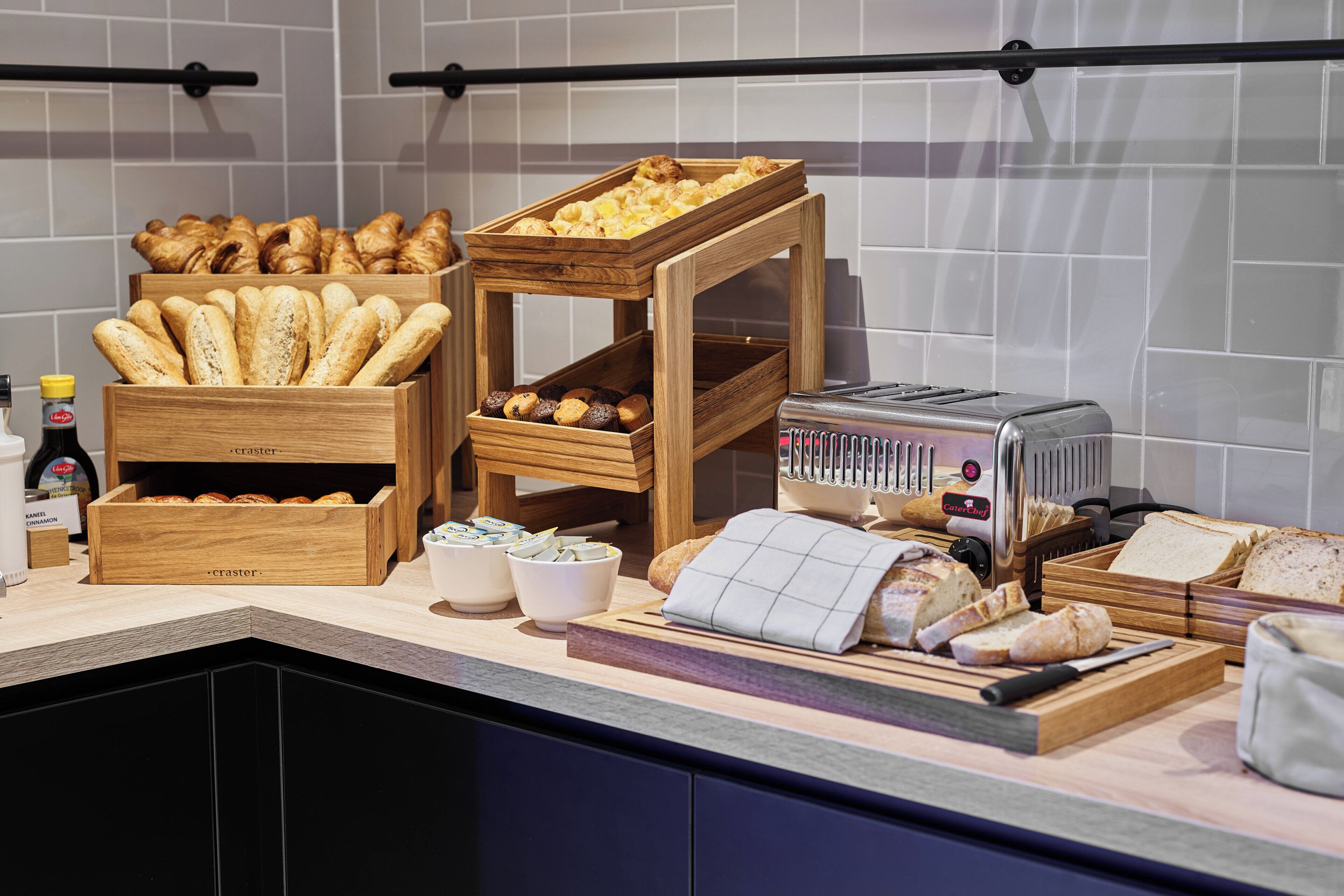 A kitchen counter with various baked goods, a toaster, and a cutting board.