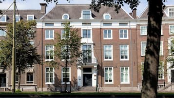 A multi-story brick building with a symmetrical facade, large windows, and a central entrance with steps.