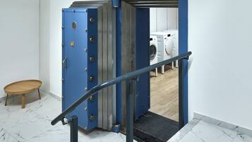 A blue metal staircase leading to a room with a washing machine.