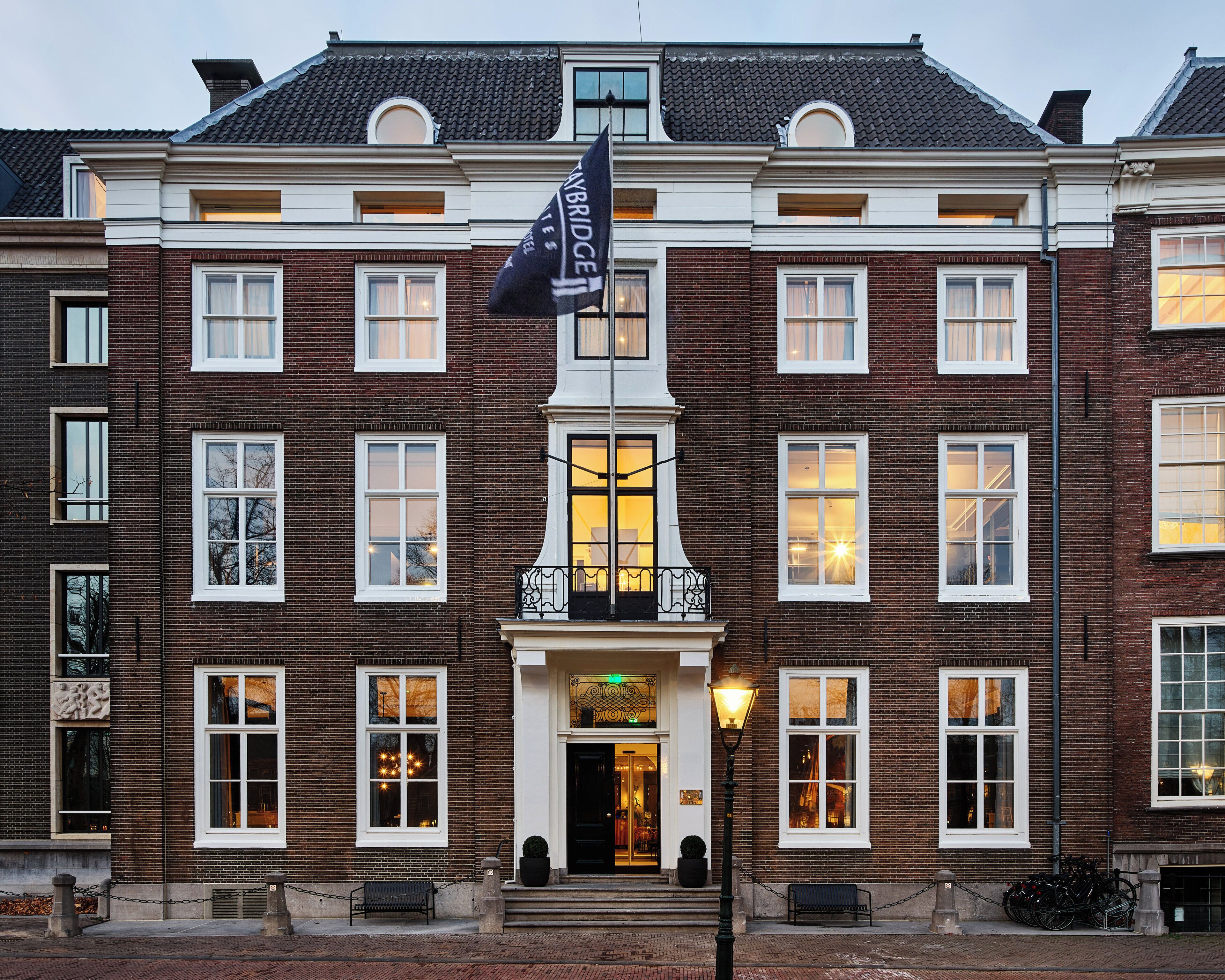 A historic building with a prominent entrance, multiple windows, and a flag.
