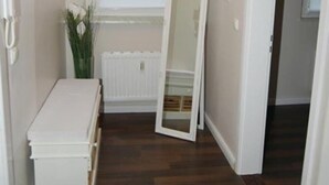 A narrow hallway with a radiator, a white bench, and a large mirror leaning against the wall. - Fachwerkhaus In Der Altstadt (Lueneburg)