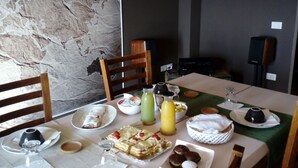 A dining area with a table set for a meal, including plates, glasses, and a variety of food items. - Cherry Season (Lanciano)