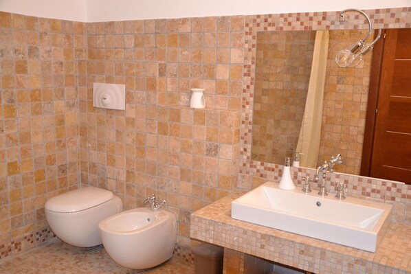 A bathroom with a tiled wall, a sink, a toilet, and a shower. - Cherry Season (Lanciano)