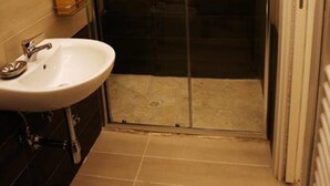 A bathroom with a glass-enclosed shower, a sink, and a towel rack. - Maison Arena (Naples)