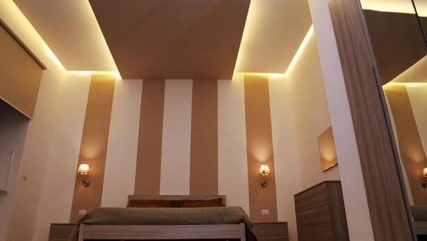 A modern bedroom with a bed, bedside tables, and a dresser. - Maison Arena (Naples)