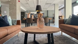 A modern interior with a round wooden table, black metal legs, and a decorative vase with dried flowers. - Emma Gjestehus (Bærum)
