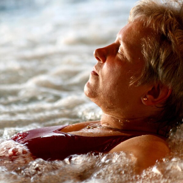 Una persona en un jacuzzi con visibles chorros de agua.