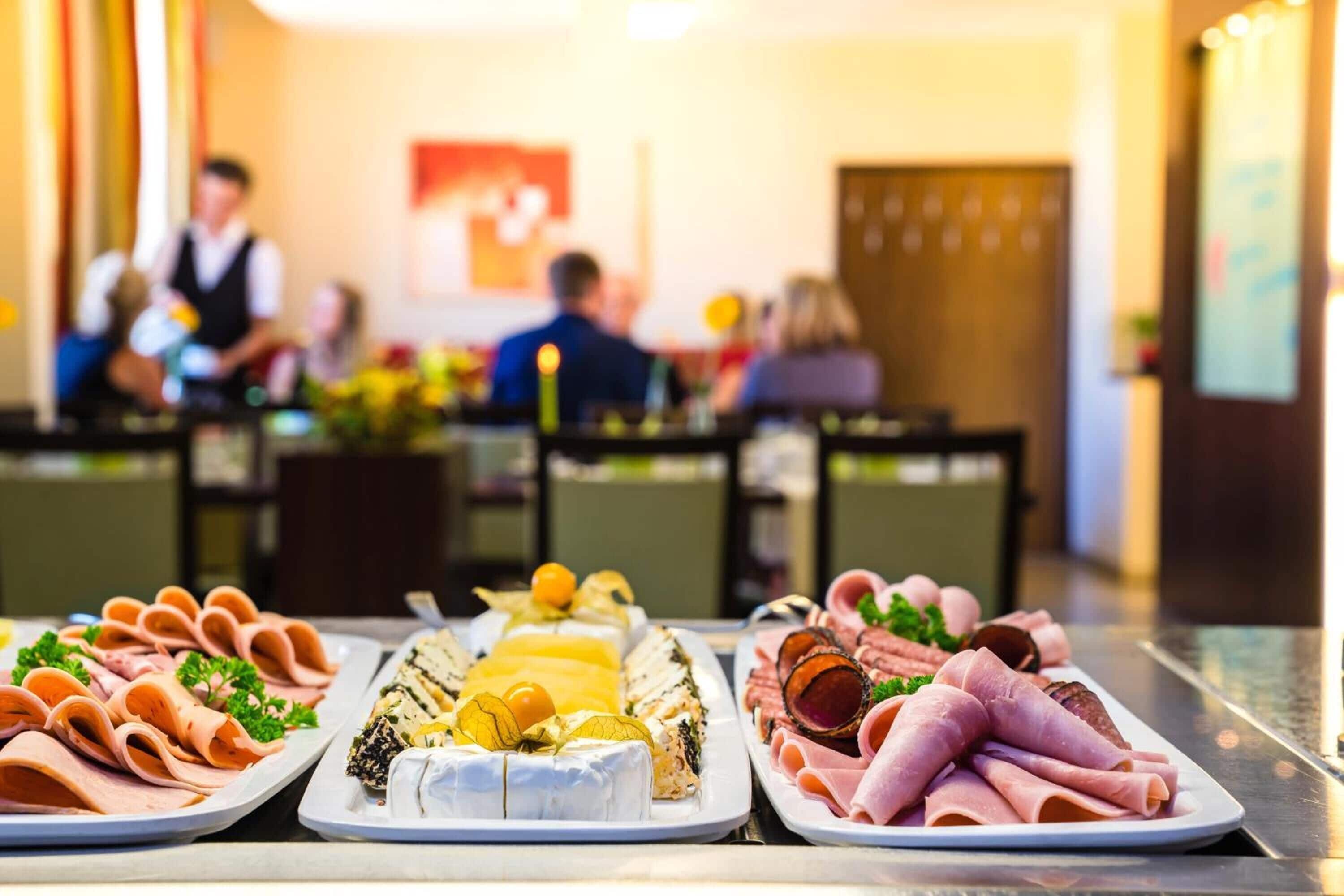 A buffet with various meats and cheeses.