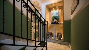 A staircase with a black metal railing leading to a landing. - Cannatella's Mansion (Palermo)