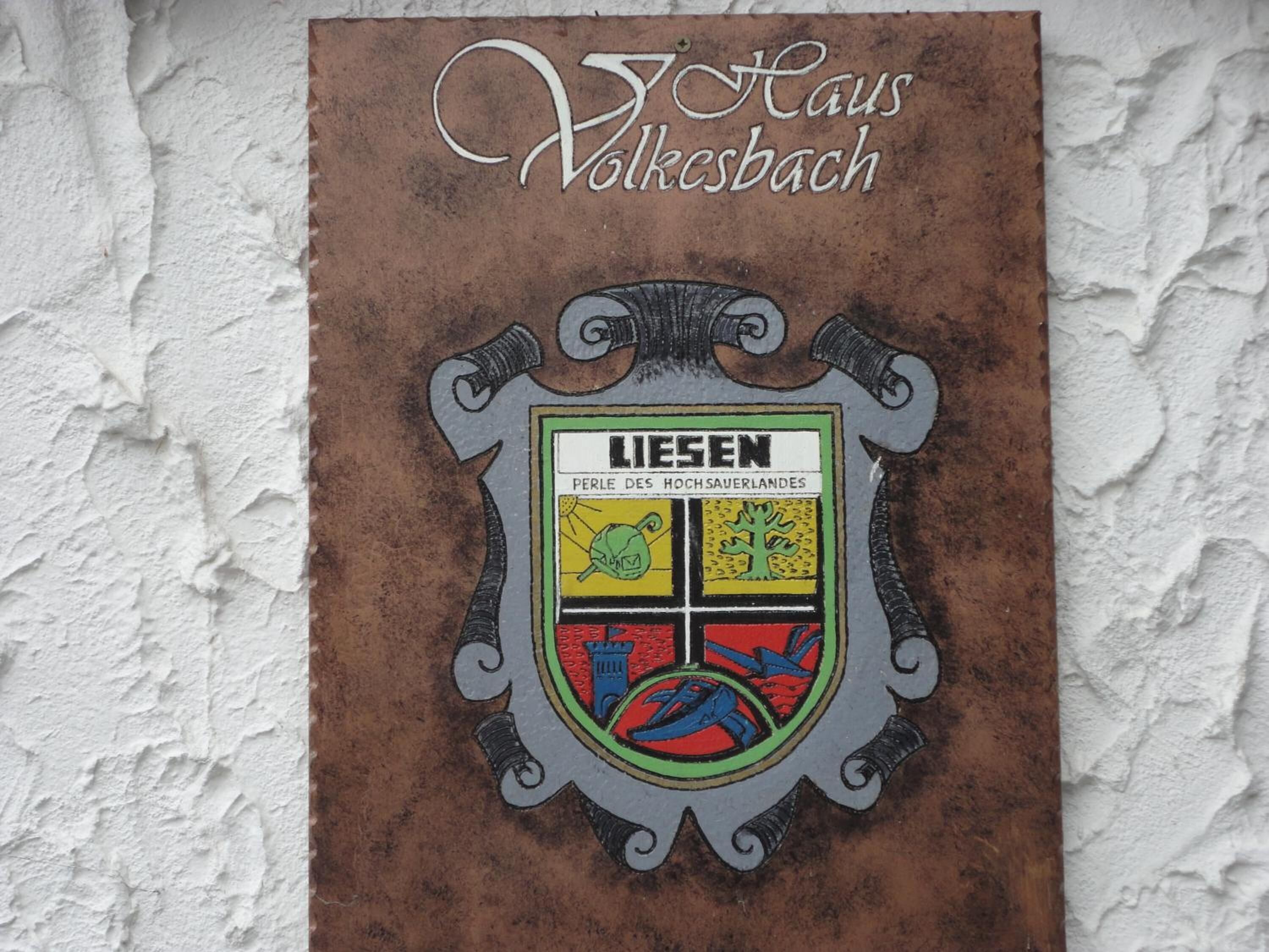 A coat of arms with the text "LIESEN PERLE DES HOCHSAUERLANDES" on a textured wall.