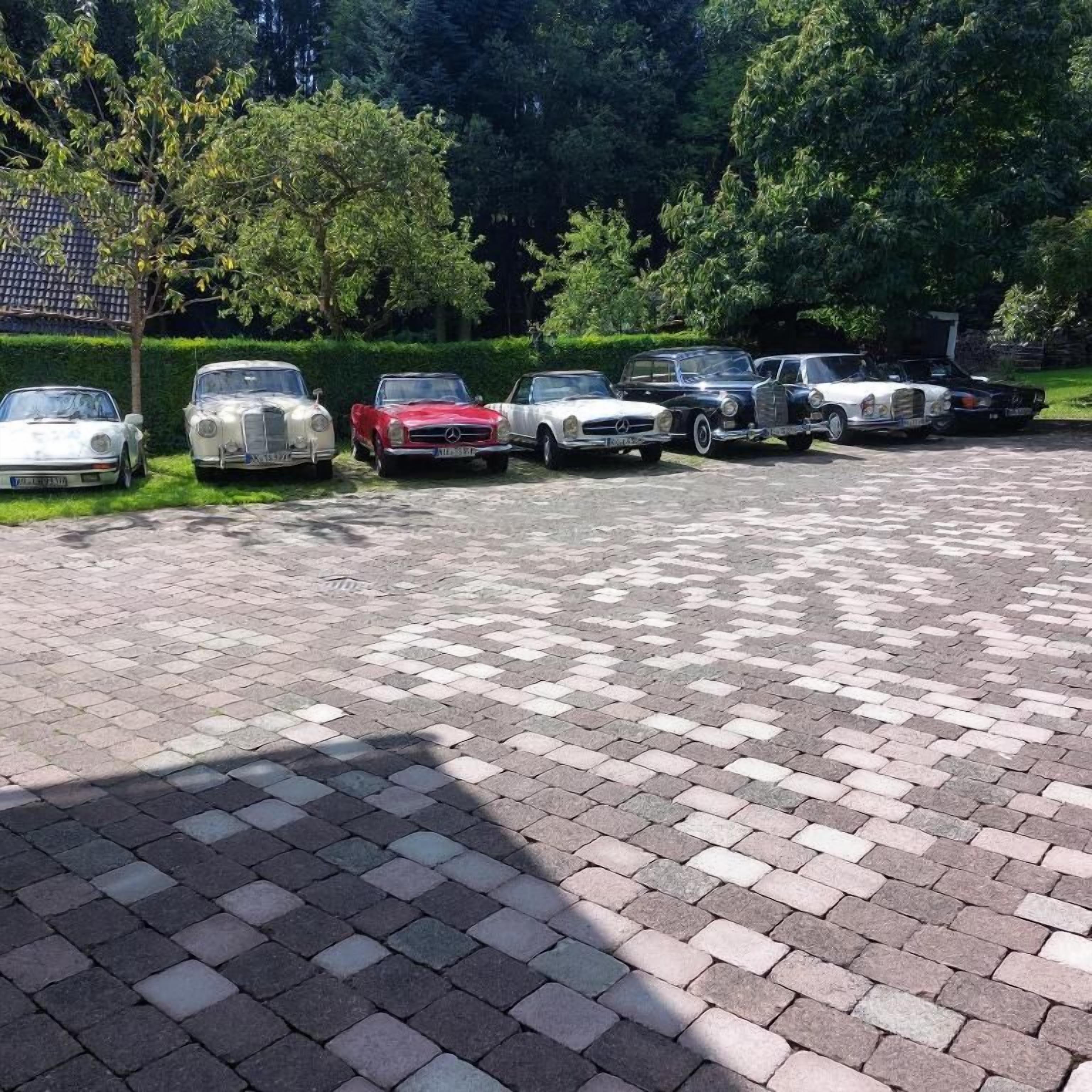 A parking area with multiple classic cars parked in a row.