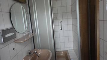 Un baño con lavamanos, espejo y ducha.