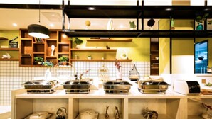 A buffet setup with various food containers and a tiled backsplash.