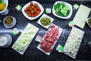 A variety of fresh fruits and vegetables on a kitchen counter.