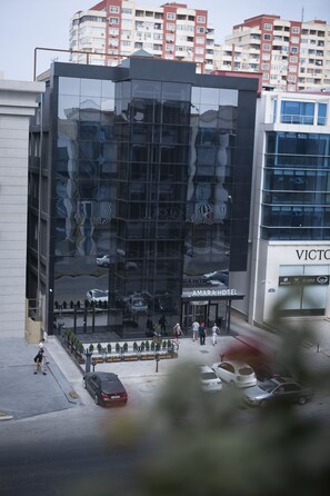 A modern hotel with a glass facade reflecting the surroundings.