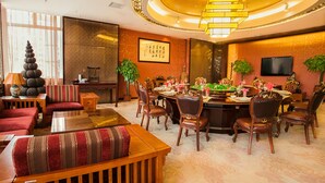 A traditional-style dining area with a round table, multiple chairs, and a chandelier. - Pengda Hotel Guangzhou (Guangzhou)