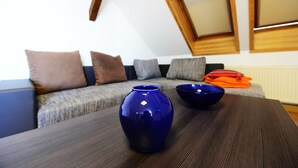 Un salon moderne avec une table basse en bois foncé, un vase bleu et un bol bleu.