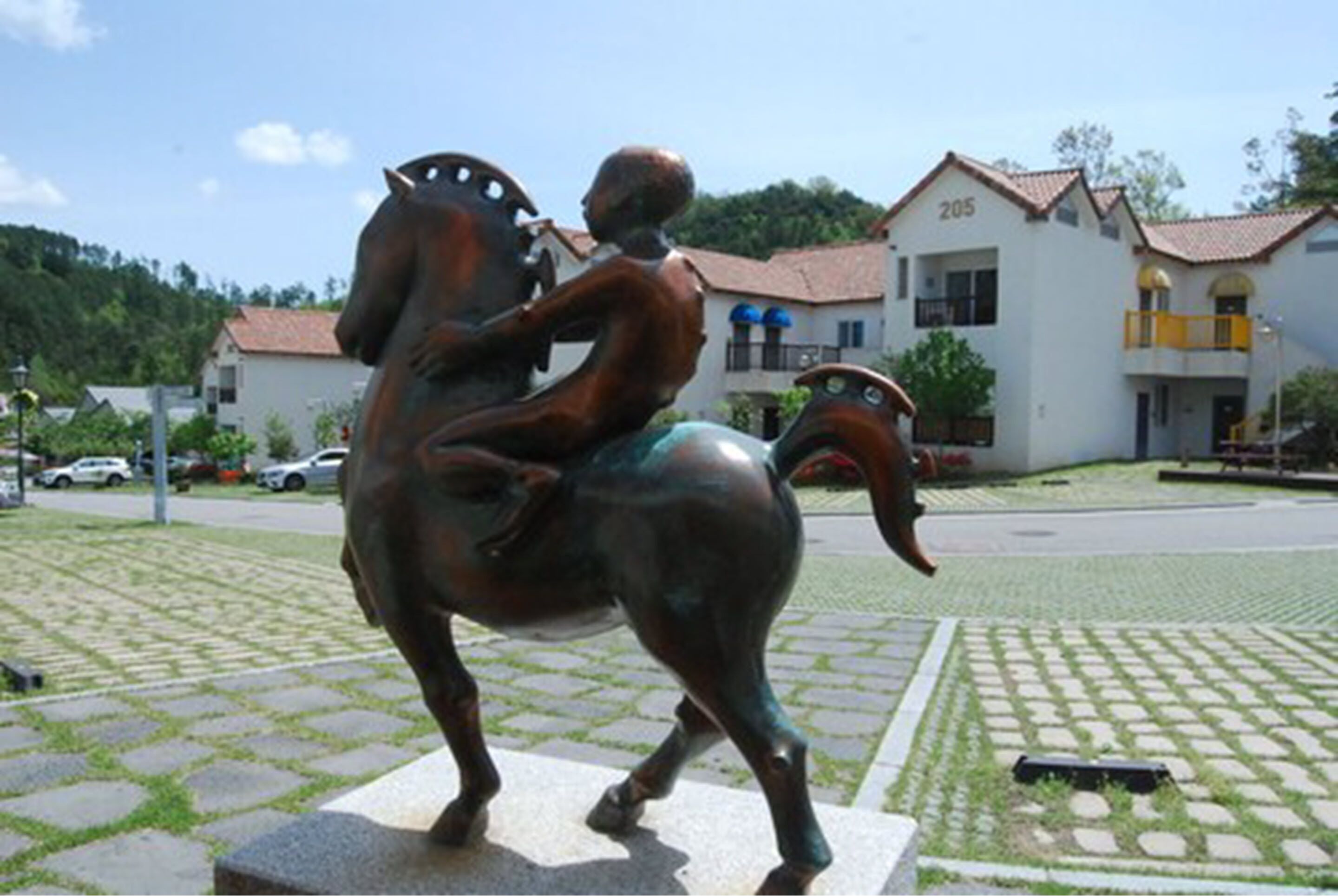 A bronze statue of a man riding a horse in a public square.