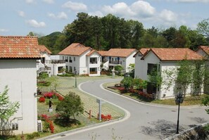 A residential area with white houses, a curved road, and greenery. - Damyang Meta Pension (Damyang)