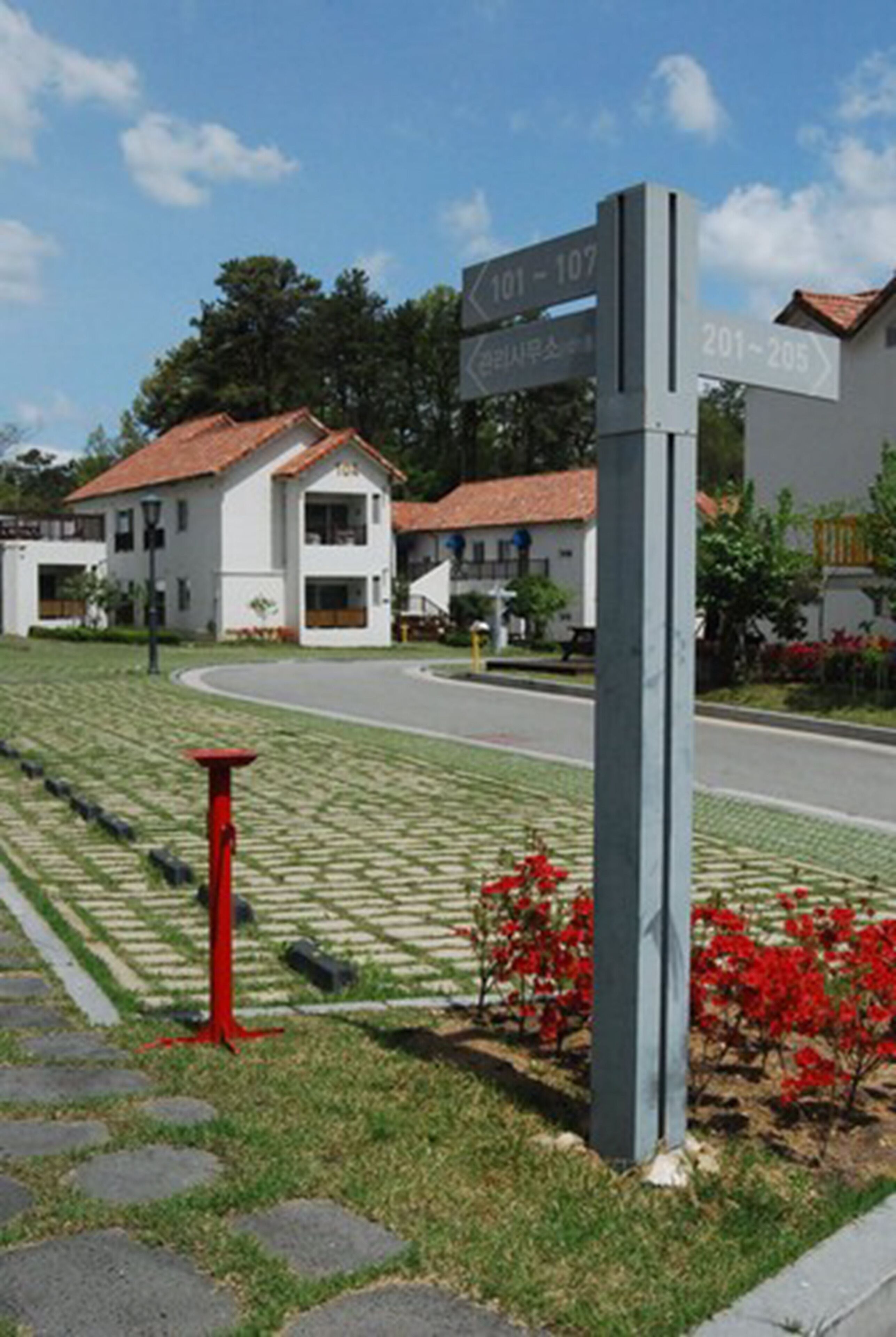 A residential area with numbered street signs indicating house numbers 101-107 and 201-205.