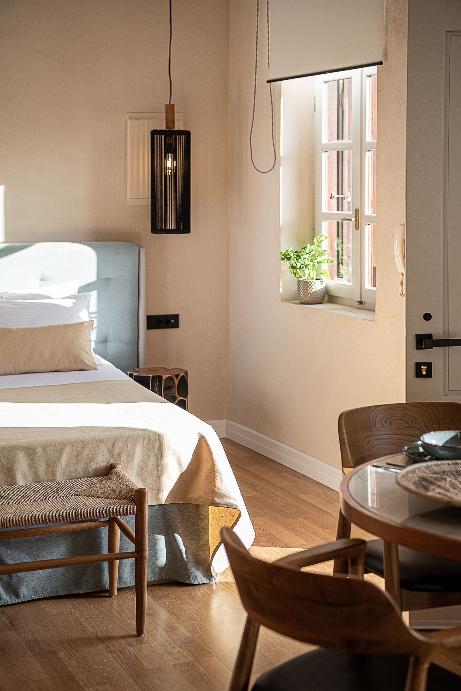 Ein Schlafzimmer mit Bett, Nachttisch und einem Fenster mit Blick.