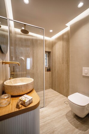 Deluxe studio suite | Badkamer | Een douche, een regendouche,  milieuvriendelijk toiletgerief