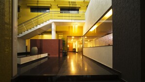 Un intérieur moderne avec un escalier, un mur en verre et un couloir bien éclairé.