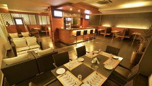 Un restaurant doté d’un bar, de différents espaces pour s’asseoir et d’une table dressée pour quatre personnes.