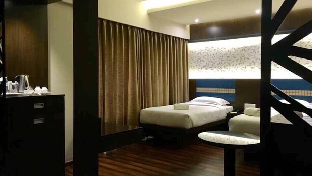 Une chambre d’hôtel comprenant un lit, une table de chevet et un bureau avec une chaise.