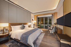 Een moderne hotelkamer met een groot bed, een bureau, een televisie en een balkon met uitzicht.