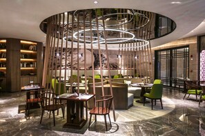Een modern interieur met een centrale zithoek, een ronde lamp en een boekenkast.