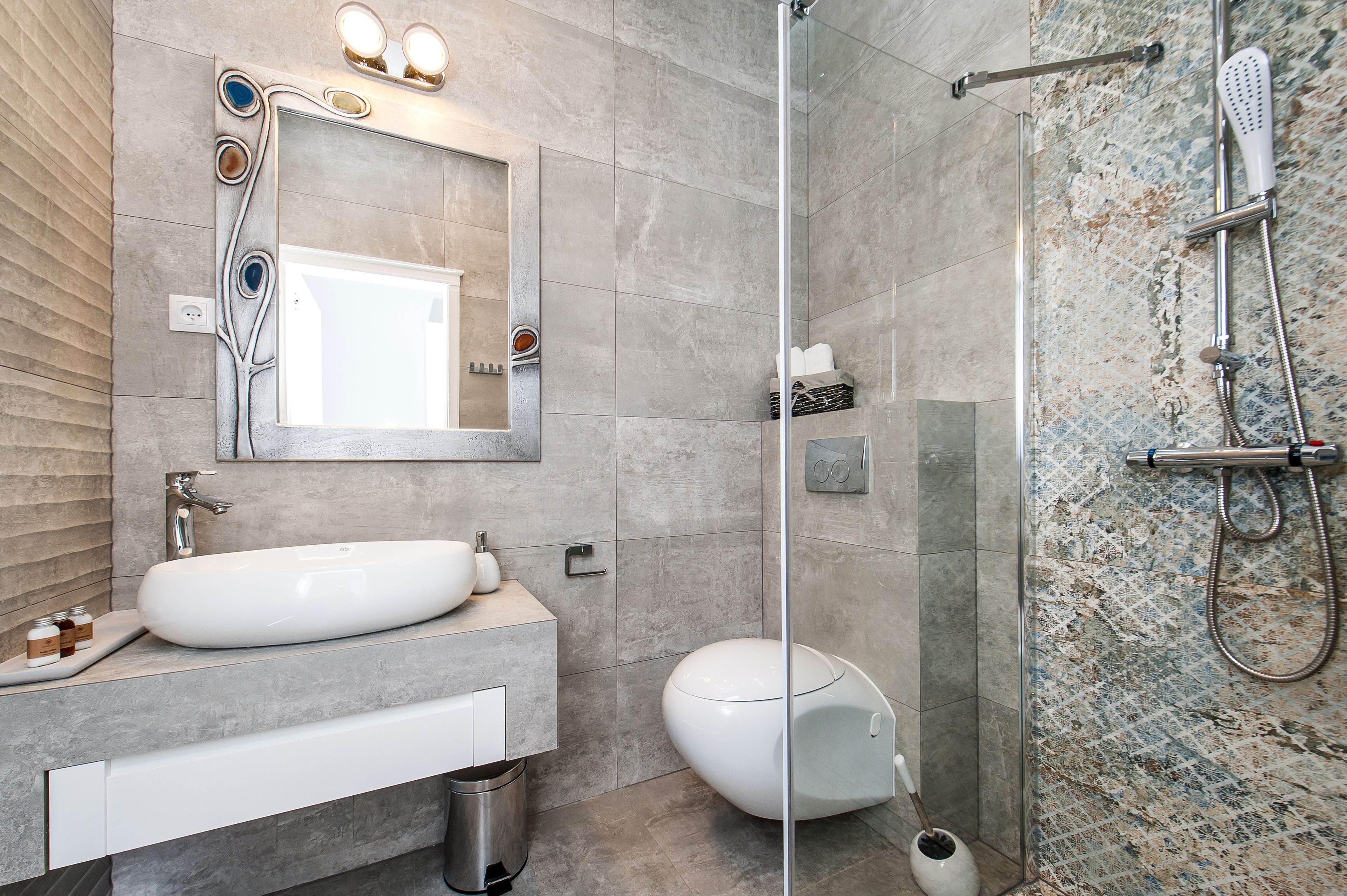 A modern bathroom with a large sink, a toilet, and a shower area.