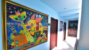 A hallway with colorful murals on the walls, a door labeled "D3-1", and a staircase. - DE Apartment (Pattaya)