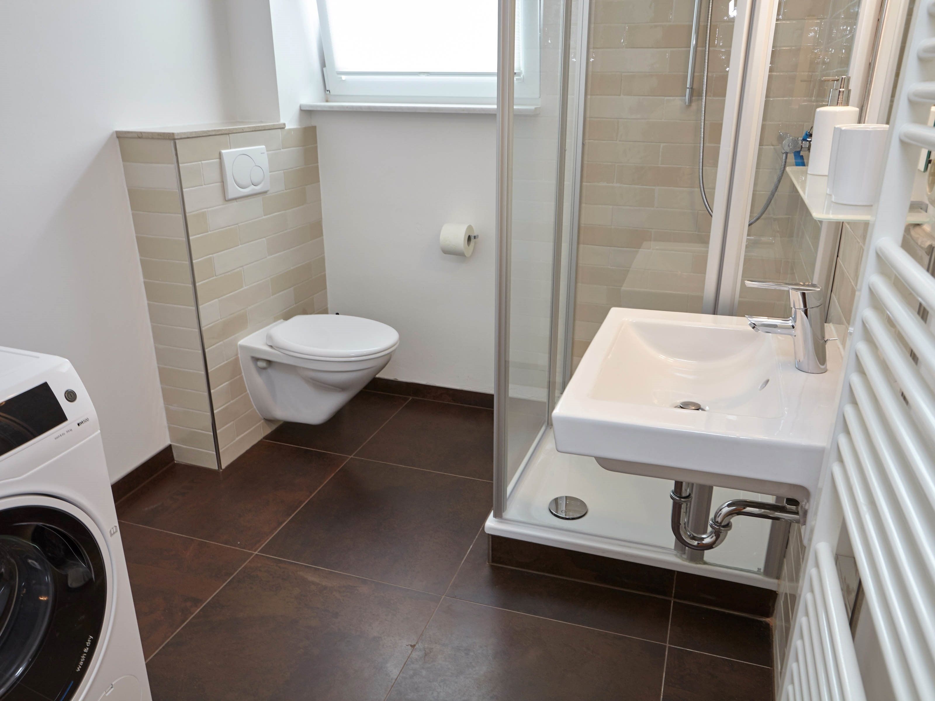 Une salle de bain moderne équipée de toilettes, d’une douche et d’un lavabo.