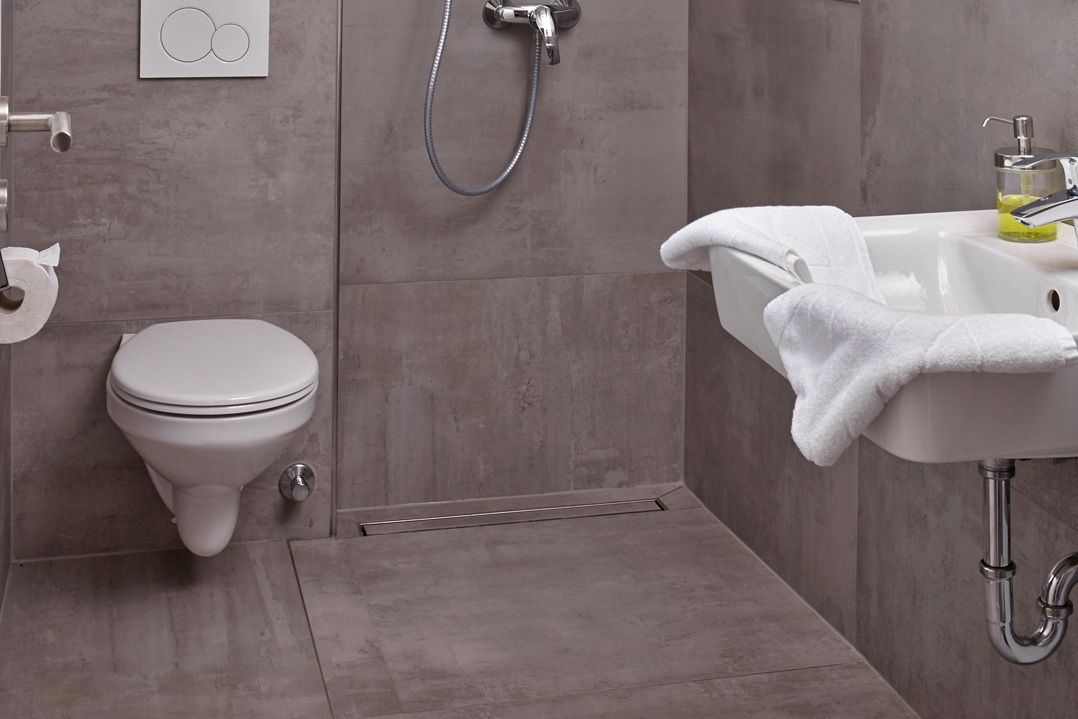 A modern bathroom with a toilet, shower, and sink.