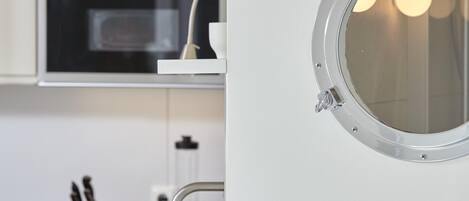 Una cocina con horno empotrado, cafetera y una olla sobre la encimera.