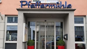 The entrance of a building with a glass door and a sign above that reads "Pfeffermühle". - Hotel Restaurant Pfeffermühle (Balingen)