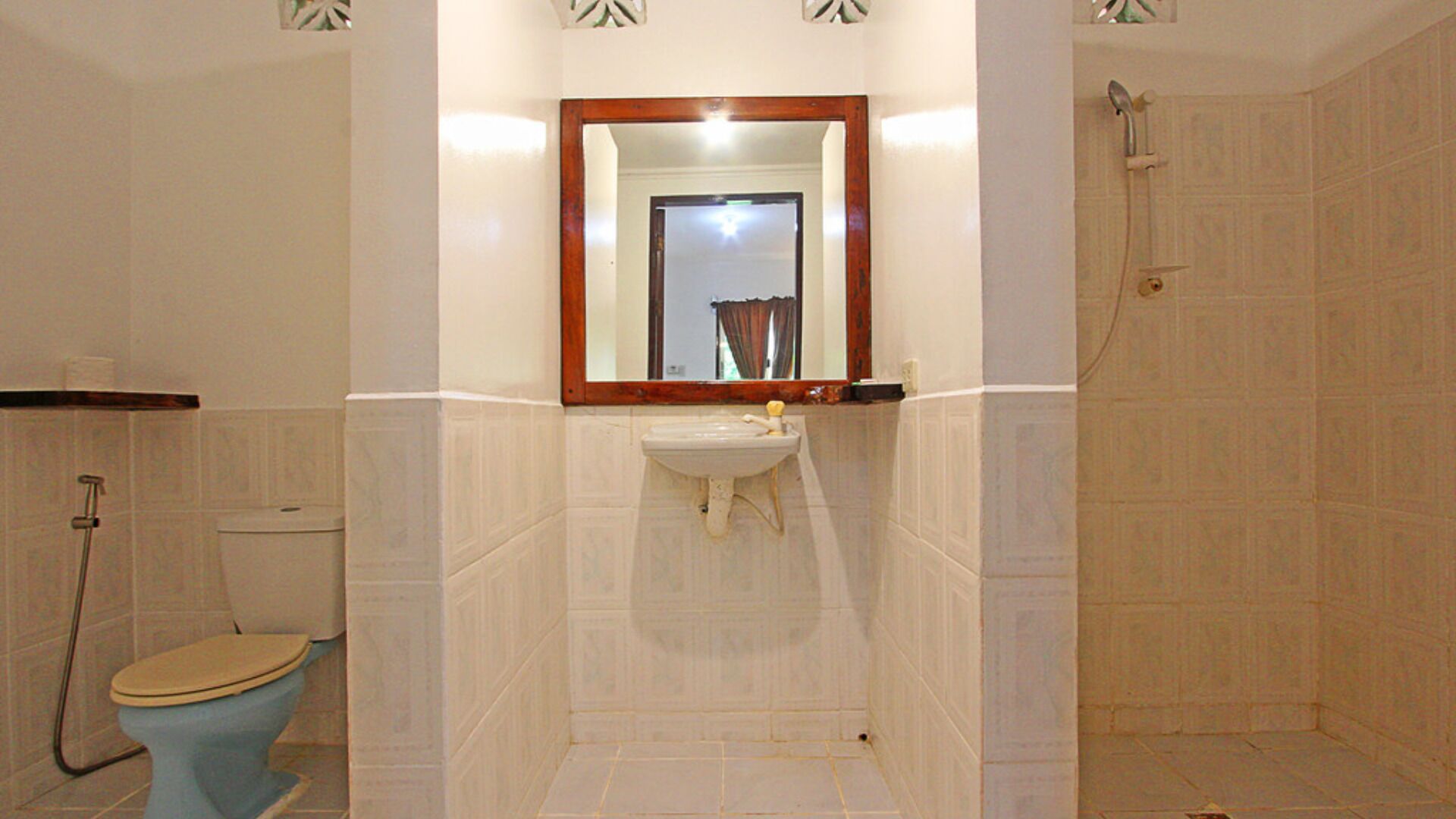 A bathroom with a toilet, sink, and shower.