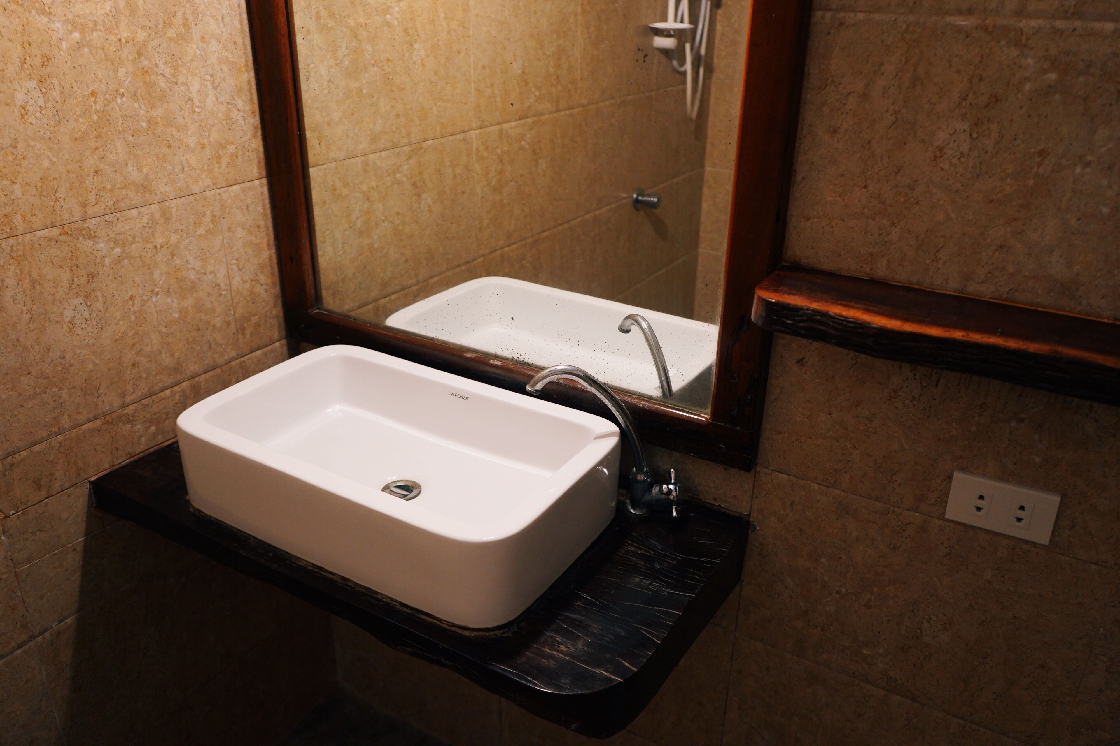 A bathroom with a white sink, a mirror, and a shower.