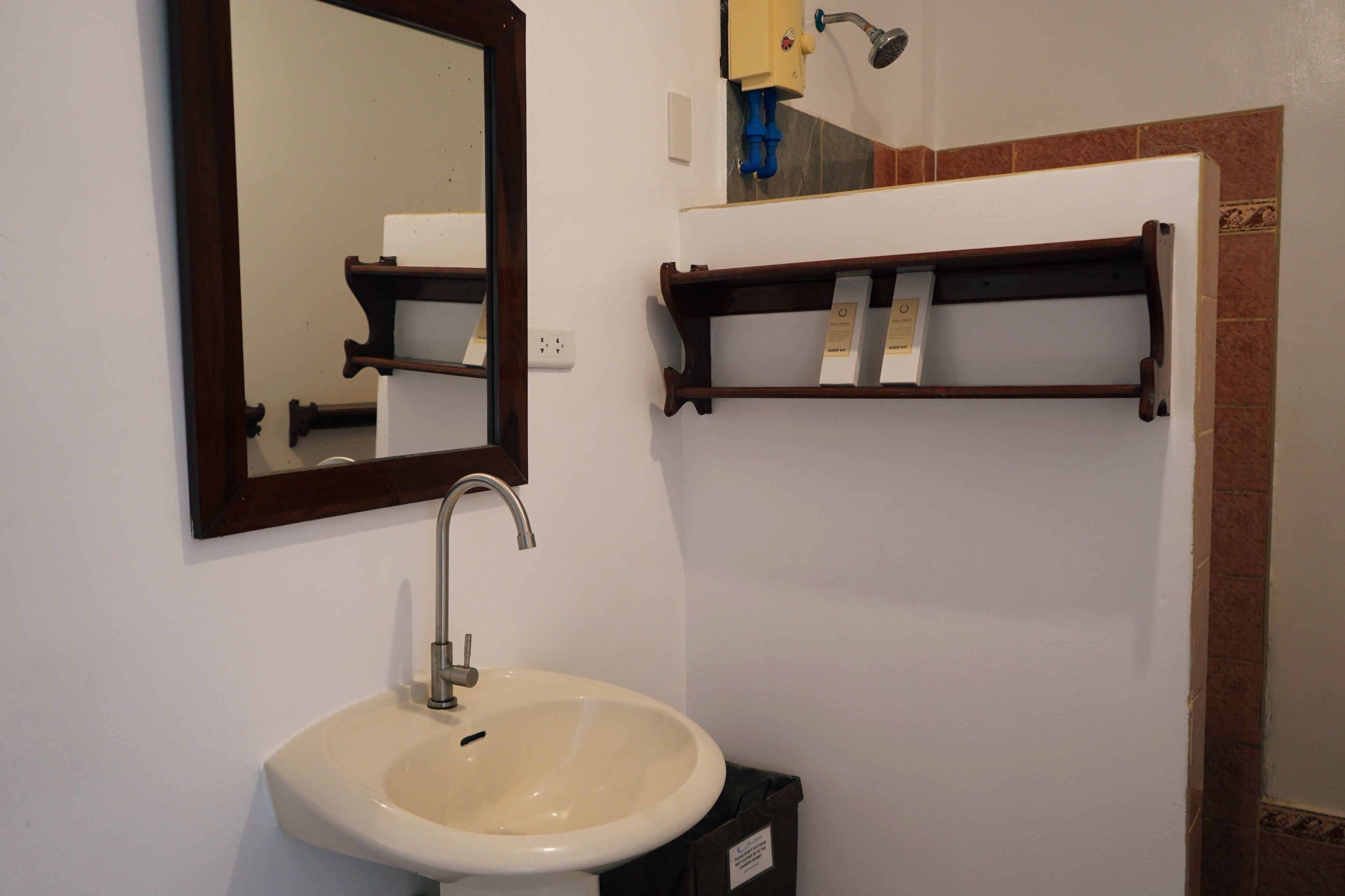 A bathroom with a sink, mirror, and towel rack.
