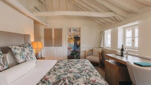 Ein Schlafzimmer mit Bett, Schreibtisch, Stuhl und Fenster.