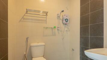 Une salle de bain avec des toilettes, une douche et un lavabo.
