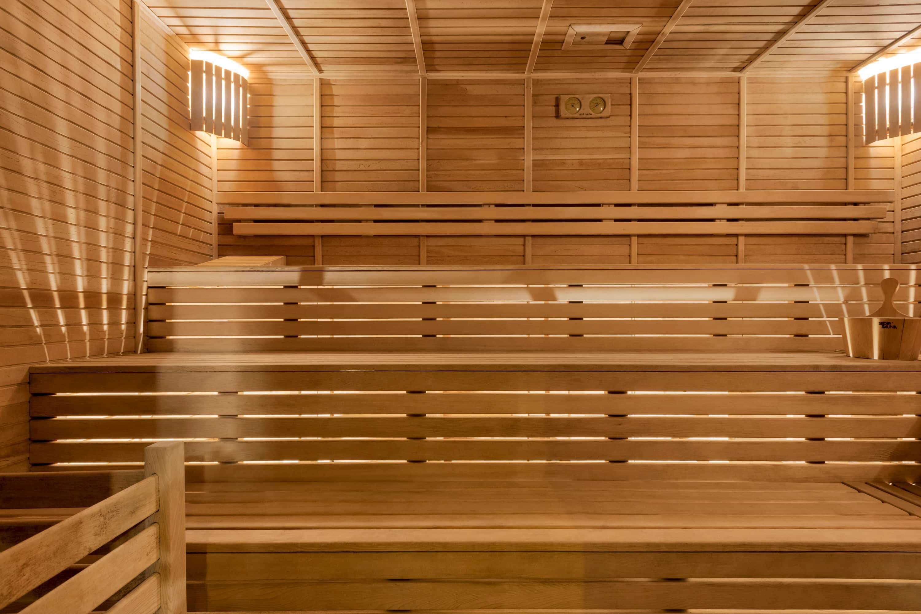Eine Holzsauna mit mehreren Bänken und einer geneigten Decke.