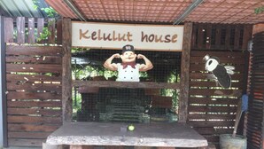 A wooden table with a sign reading "Kelulut House" and a cartoon chef figure.