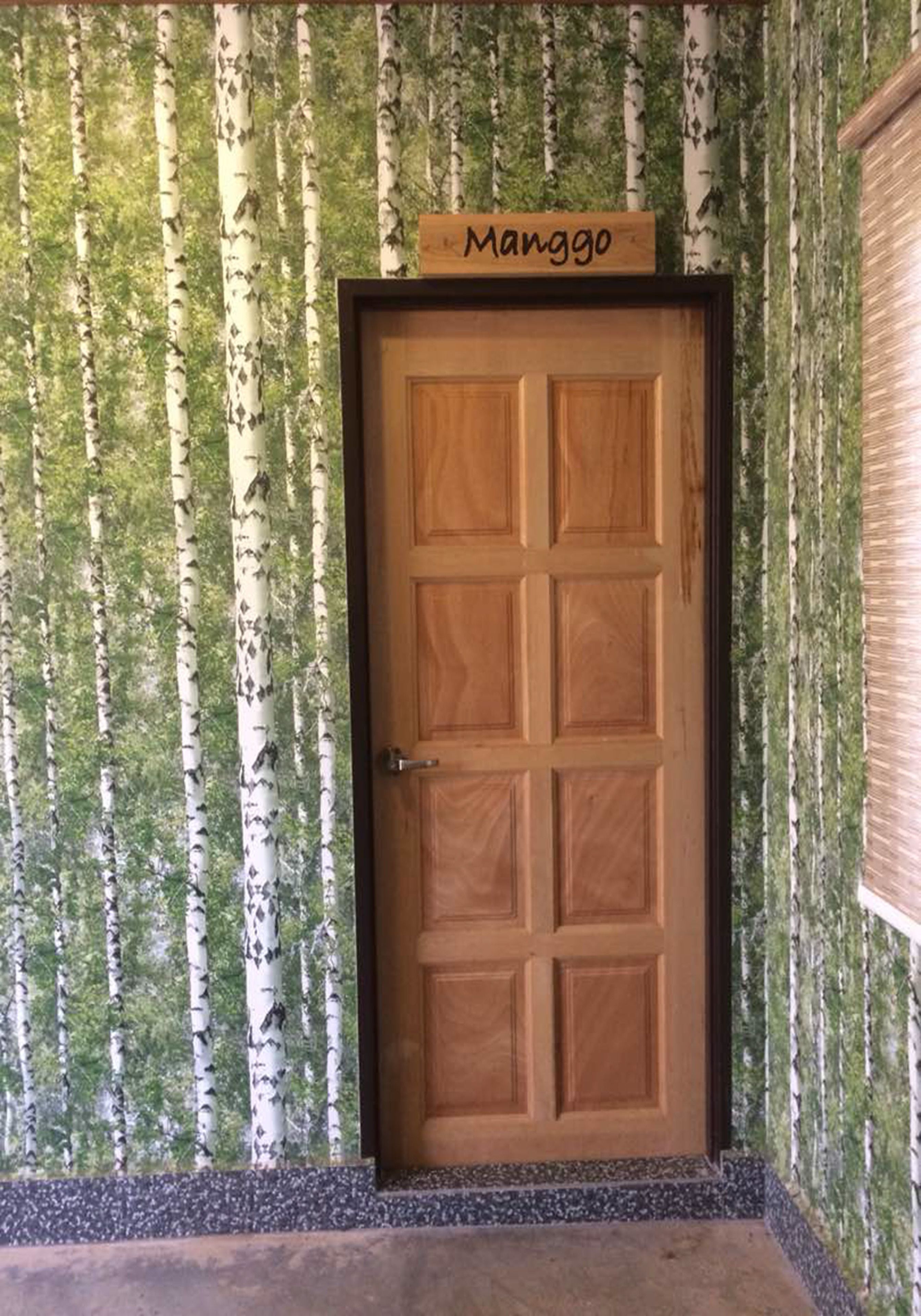 A wooden door with a sign above it reading "Manggo."